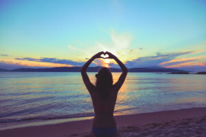 girl,holding,a,heart,shape,for,the,ocean,/,sea.